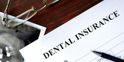 a dental insurance form set on a brown wooden table
