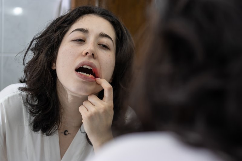 Patient checking their gums for gingivitis in the mirror