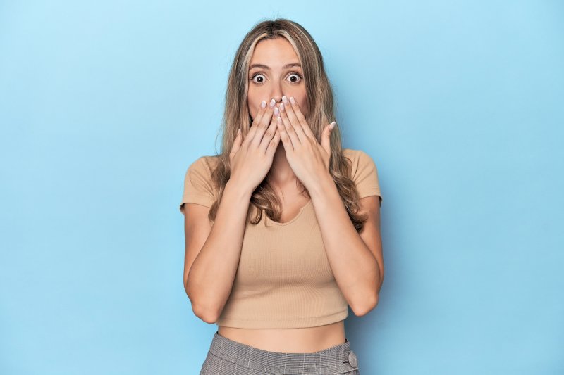 a surprised woman covering her mouth